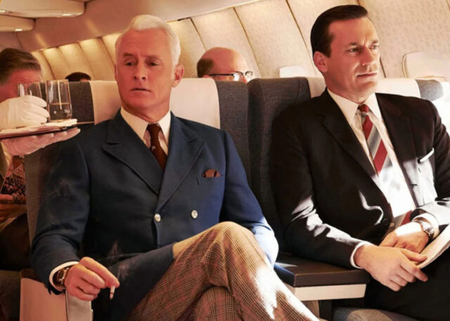 Two men in suits share travel tips.