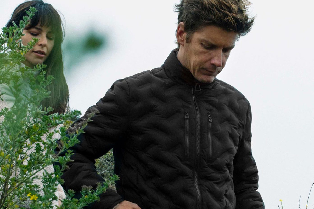 A couple outdoors in fashionable clothing.