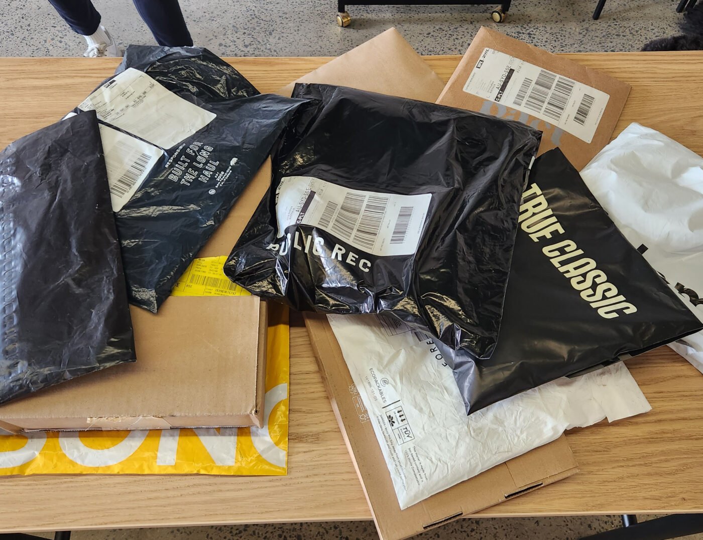 A selection of white tees in delivery packaging