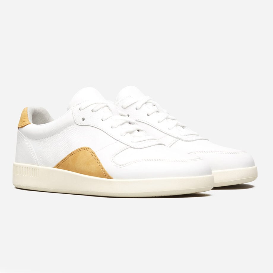 Trendy white sneakers with tan accents.