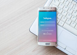 Instagram login screen displayed on smartphone over laptop.