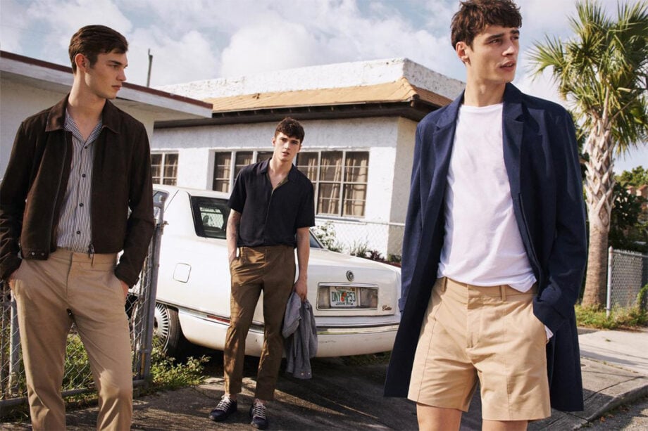 Three men discuss Black Friday near house.