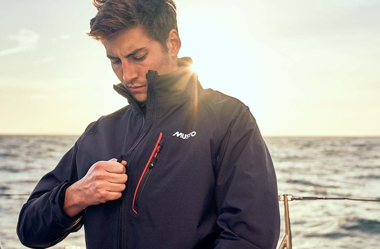 Man zips Musto jacket aboard.