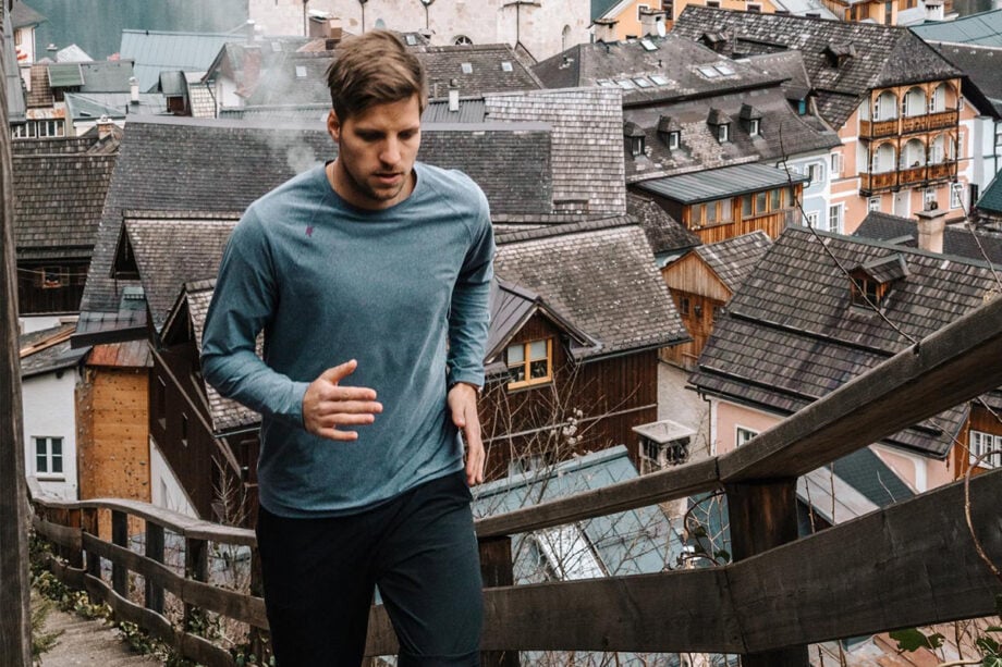 Man jogs up stairs in scenic village.