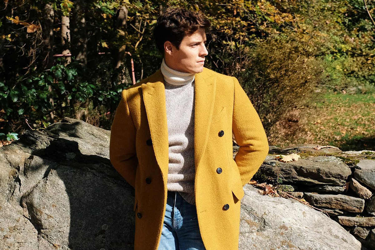 Person in mustard coat, ponders Black Friday sales.